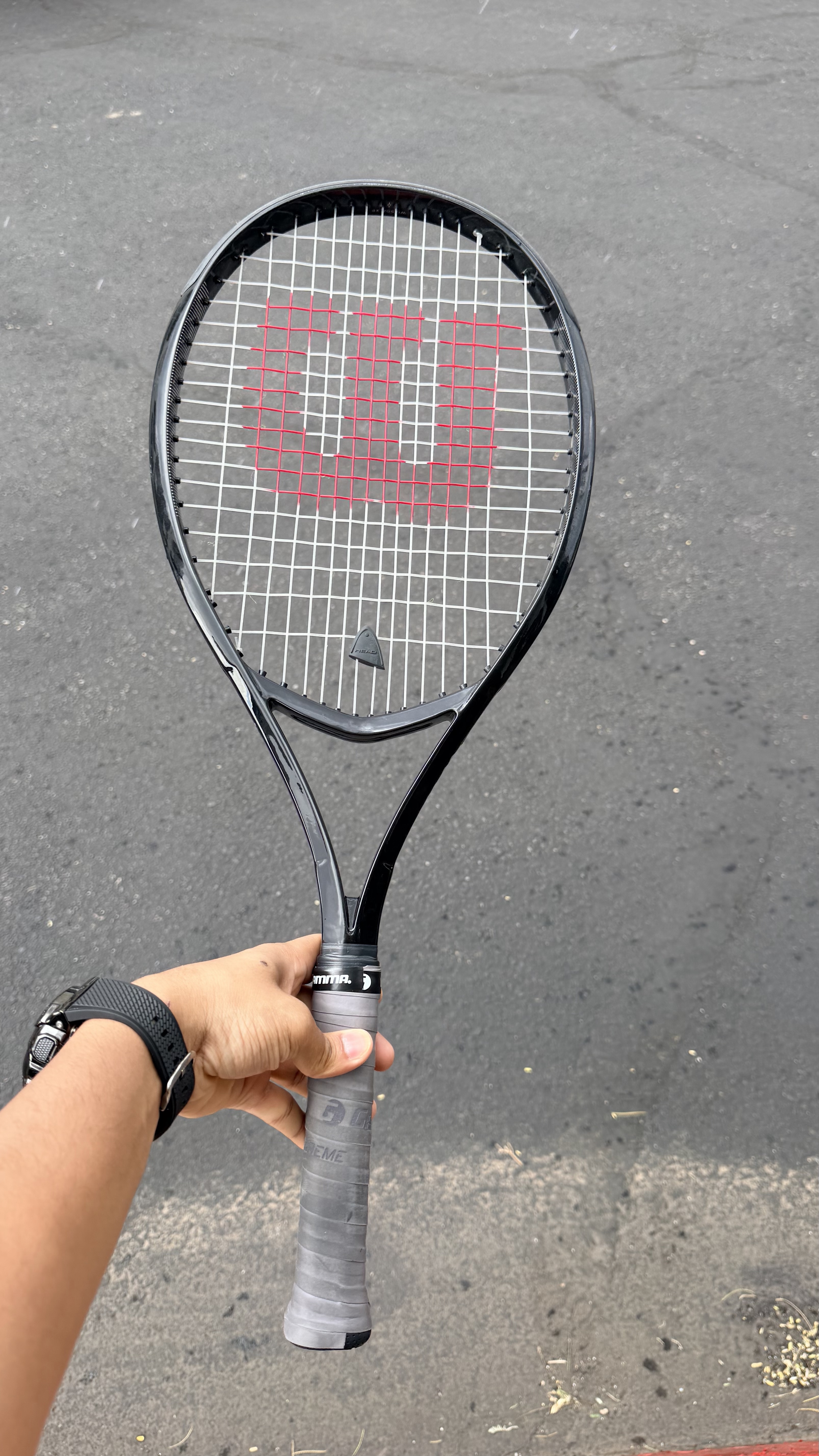 Tennis racket with Wilson logo held in hand